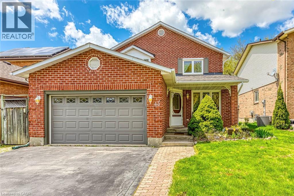Brick facade residence featuring an attached garage with decorative window inserts, an arched entryway, and a covered porch - 43 Niska Drive, Waterdown, ON - Outdoor