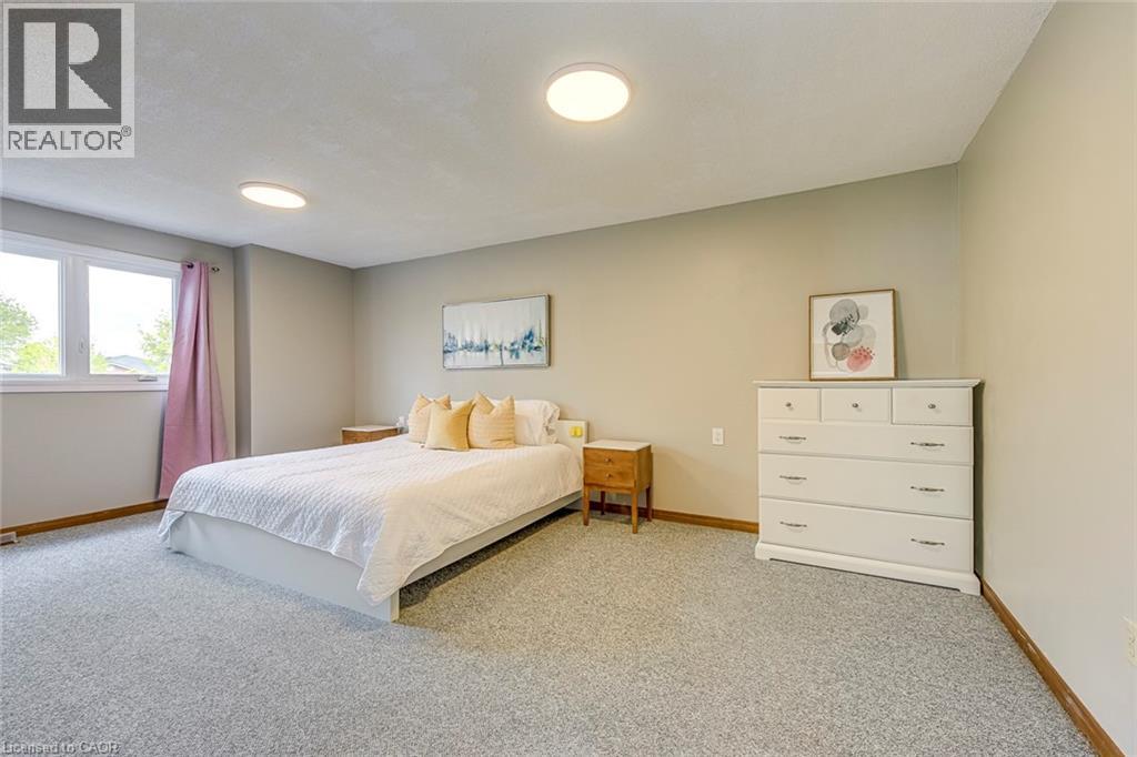 Spacious room featuring neutral-toned walls, light-colored carpeting, and a large window - 43 Niska Drive, Waterdown, ON - Indoor Photo Showing Bedroom