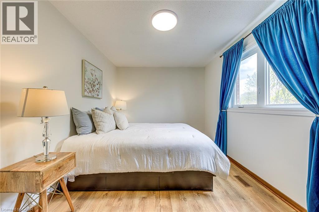 Spacious room with wood-finish flooring, a bright window, and a ceiling-mounted light fixture - 43 Niska Drive, Waterdown, ON - Indoor Photo Showing Bedroom