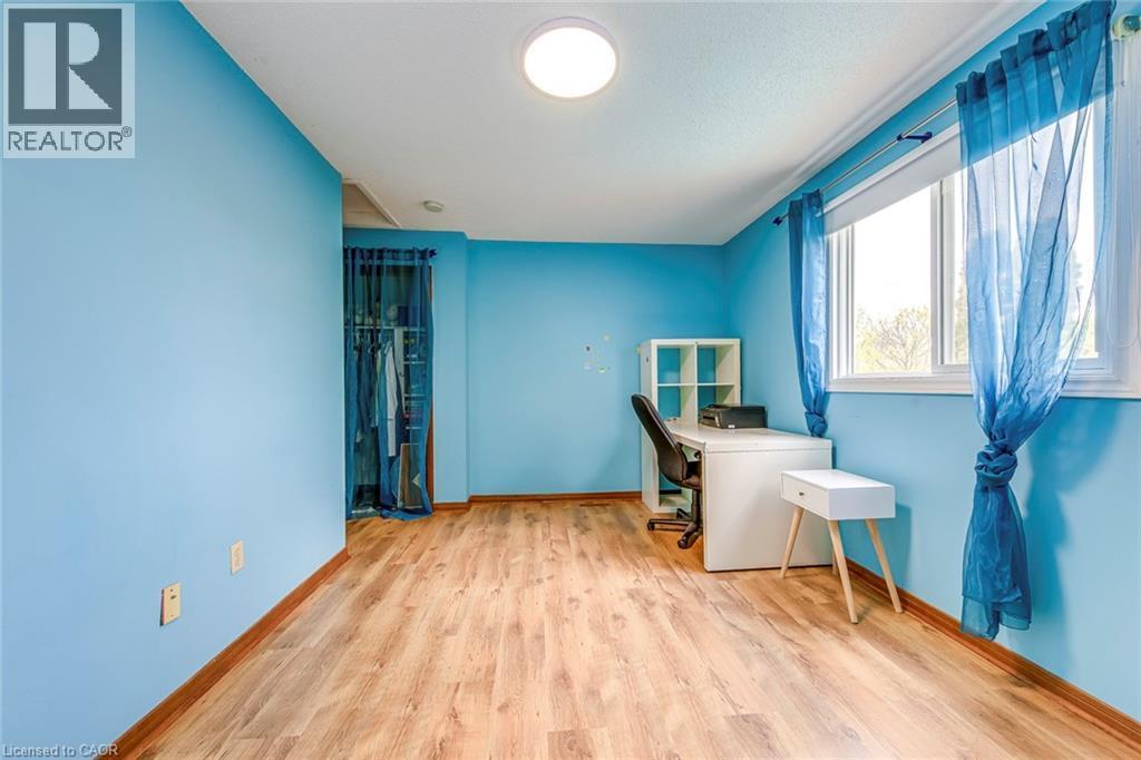Room featuring wood-finish flooring, a window with natural light, a built-in closet, and a ceiling-mounted light fixture - 43 Niska Drive, Waterdown, ON - Indoor Photo Showing Other Room