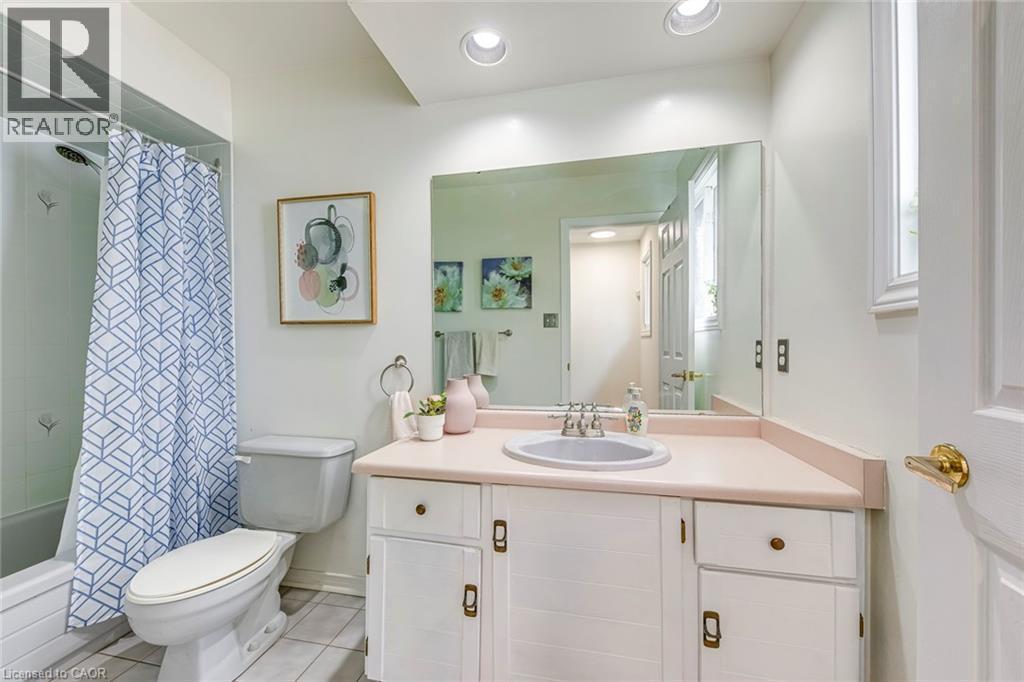 Full bathroom featuring a single vanity with a built-in sink, white cabinetry, and a large wall-mounted mirror - 43 Niska Drive, Waterdown, ON - Indoor Photo Showing Bathroom