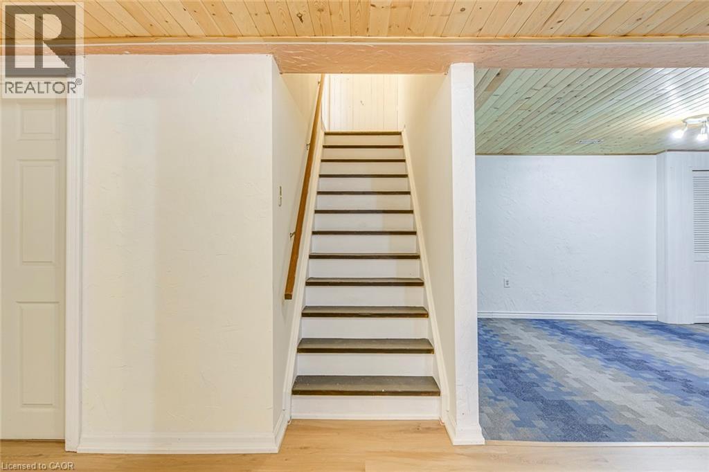 Staircase with wood treads and white risers, featuring a wood handrail - 43 Niska Drive, Waterdown, ON - Indoor Photo Showing Other Room
