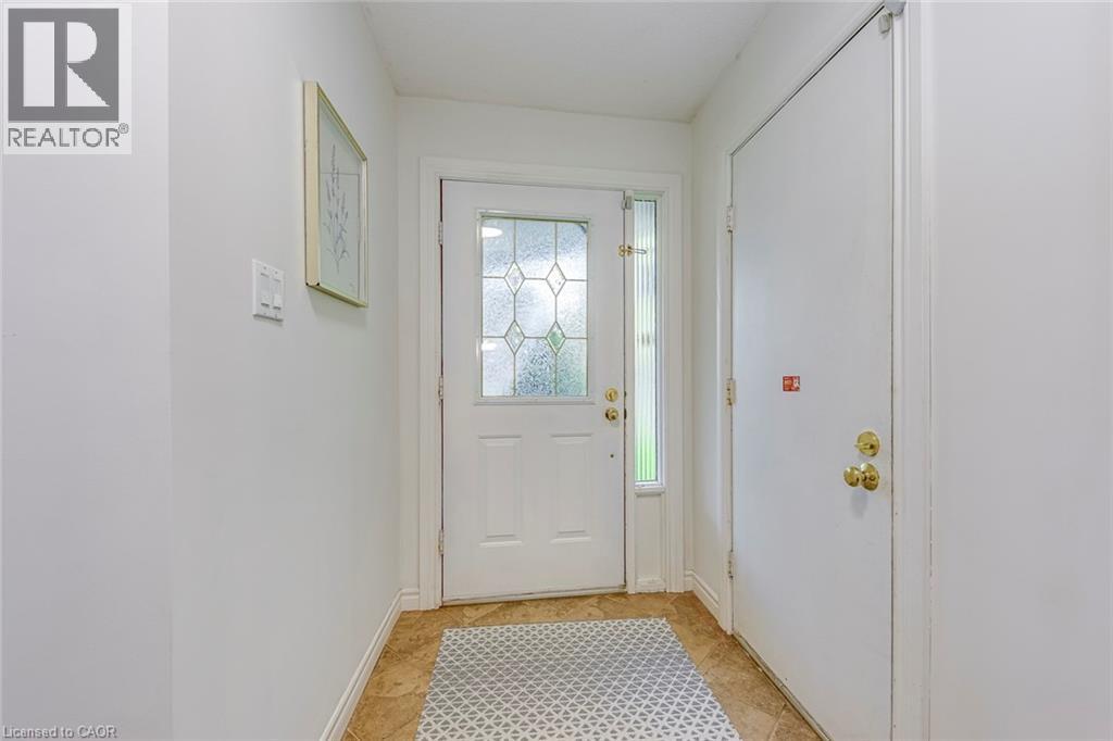 Entryway featuring a white door with decorative glass inserts, a full-length sidelight, and brass hardware - 43 Niska Drive, Waterdown, ON - Indoor Photo Showing Other Room
