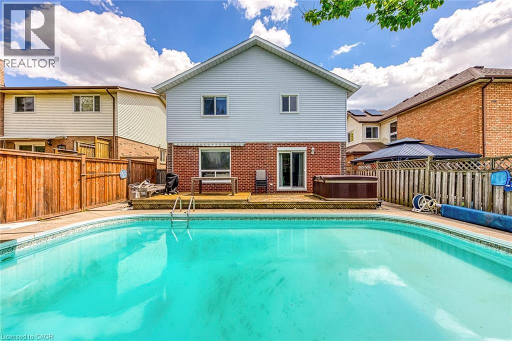 In-ground swimming pool featuring a ladder and surrounding concrete coping - 43 Niska Drive, Waterdown, ON - Outdoor With In Ground Pool With Deck Patio Veranda