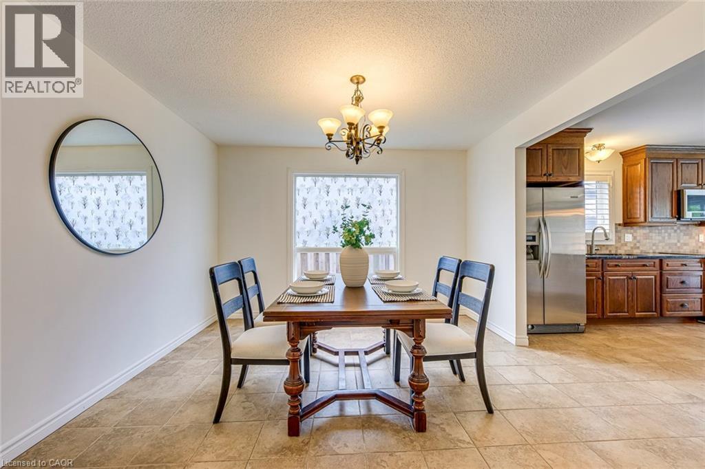 Dining area featuring tile flooring, a chandelier, and a window with a patterned privacy film - 43 Niska Drive, Waterdown, ON - Indoor Photo Showing Dining Room