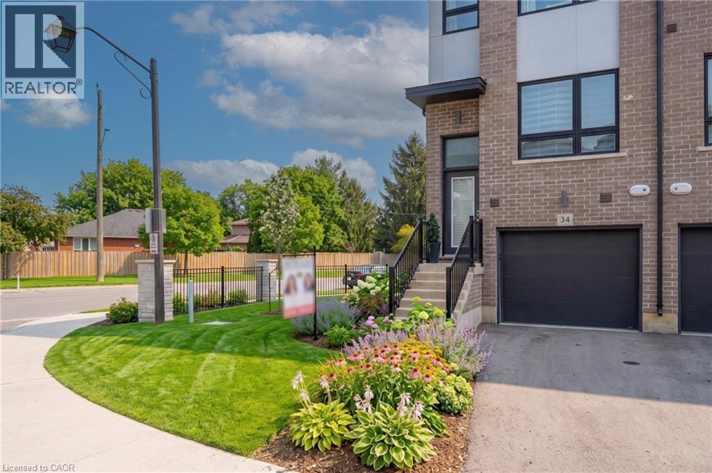 Modern brick townhouse with a black garage door and private entrance - 720 Grey Street Unit# 34, Brantford, ON - Outdoor