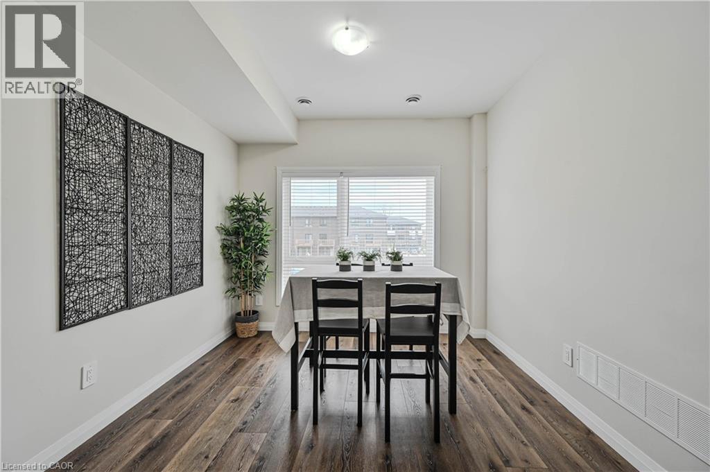 Bright room with wood-finish flooring, white baseboards, and a window with horizontal blinds - 720 Grey Street Unit# 34, Brantford, ON - Indoor Photo Showing Dining Room