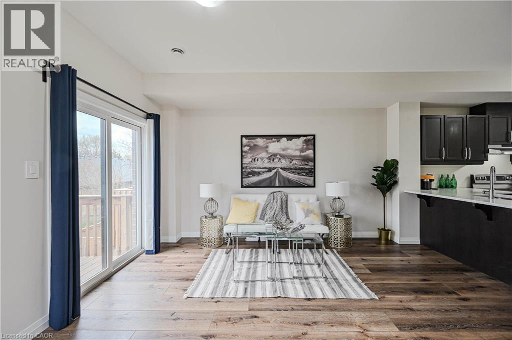 Open-concept living area with wide wood-finish flooring, white walls, and a recessed ceiling light - 720 Grey Street Unit# 34, Brantford, ON - Indoor Photo Showing Bedroom