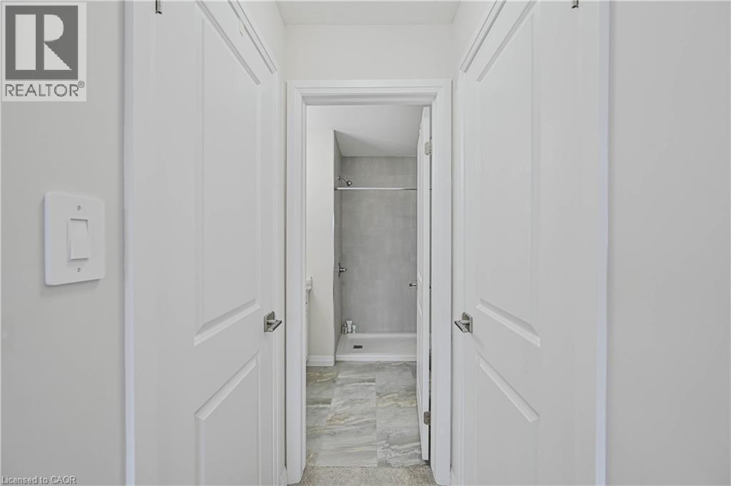 Hallway leading to a bathroom featuring a tile shower surround and a shower/tub combination - 720 Grey Street Unit# 34, Brantford, ON - Indoor Photo Showing Other Room