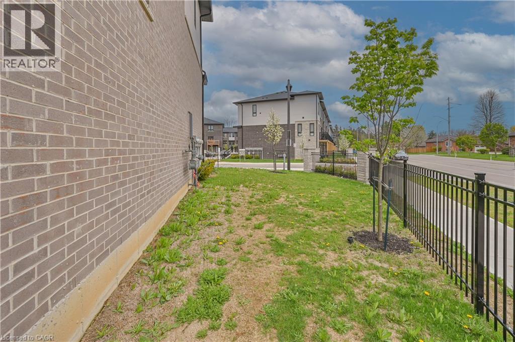 Brick exterior with a black metal fence and established landscaping - 720 Grey Street Unit# 34, Brantford, ON - Outdoor