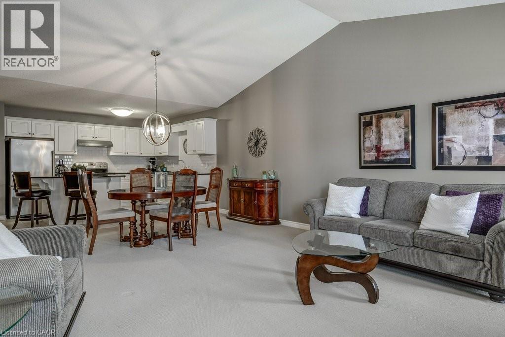 Open-concept living area featuring a vaulted ceiling, light gray wall paint, and plush carpeting - 605 Welland Avenue Unit# 21, St. Catharines, ON - Indoor Photo Showing Living Room