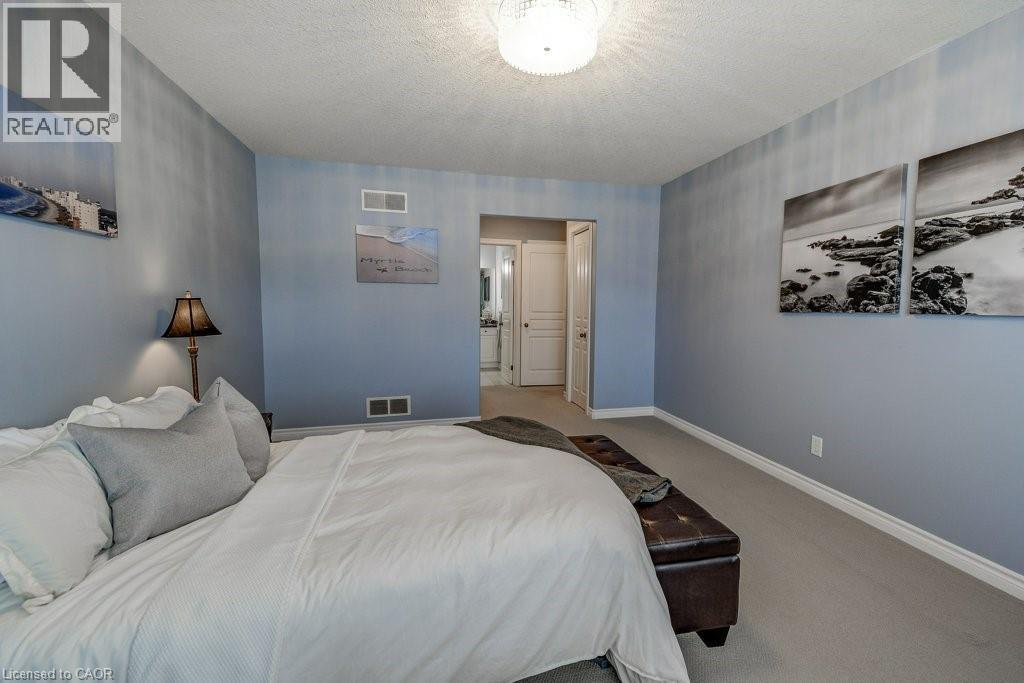 Spacious bedroom featuring light blue walls and neutral carpeting - 605 Welland Avenue Unit# 21, St. Catharines, ON - Indoor Photo Showing Bedroom