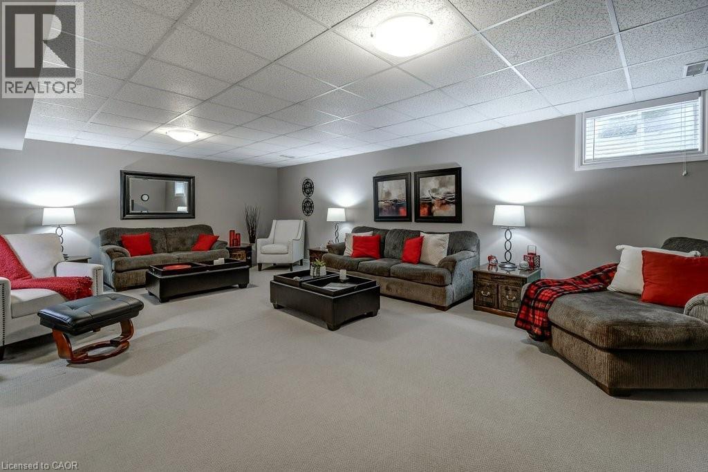 Carpeted lower-level living area featuring neutral wall tones and a grid ceiling - 605 Welland Avenue Unit# 21, St. Catharines, ON - Indoor Photo Showing Basement