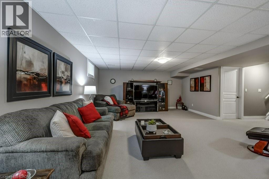 Spacious recreation room featuring light gray walls, plush carpeting, and a dropped ceiling with recessed lighting - 605 Welland Avenue Unit# 21, St. Catharines, ON - Indoor