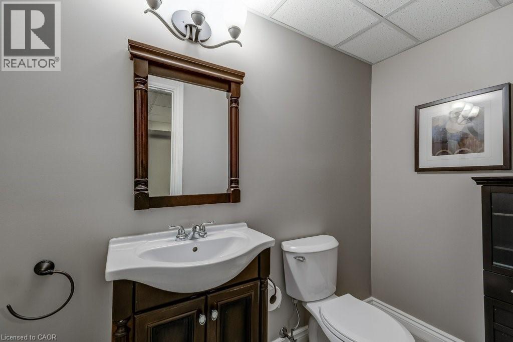 Bathroom featuring a dark wood-finish vanity with an integrated white sink and a chrome faucet - 605 Welland Avenue Unit# 21, St. Catharines, ON - Indoor Photo Showing Bathroom