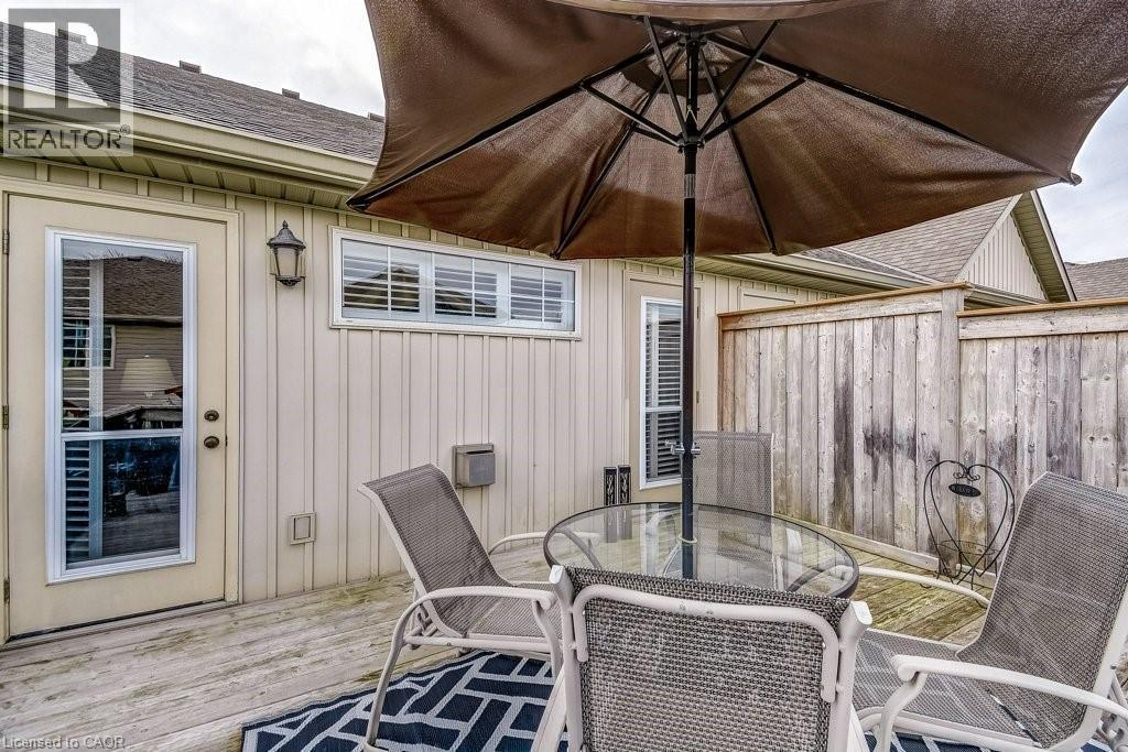 Outdoor deck area featuring wood-finish flooring, a full-lite exterior door, and a horizontal window with blinds - 605 Welland Avenue Unit# 21, St. Catharines, ON - Outdoor With Deck Patio Veranda With Exterior