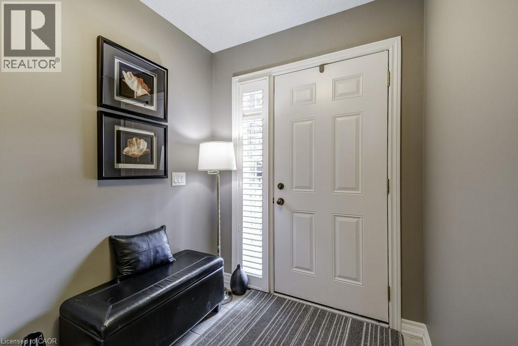 Entryway featuring a paneled door, sidelight with internal blinds, and neutral wall paint - 605 Welland Avenue Unit# 21, St. Catharines, ON - Indoor Photo Showing Other Room