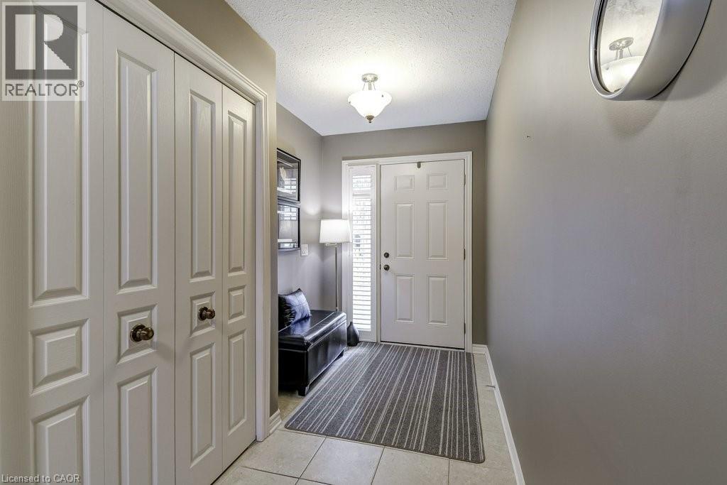 Entryway featuring a paneled door with side lite, light-toned tile flooring, and a built-in closet with bi-fold doors - 605 Welland Avenue Unit# 21, St. Catharines, ON - Indoor Photo Showing Other Room