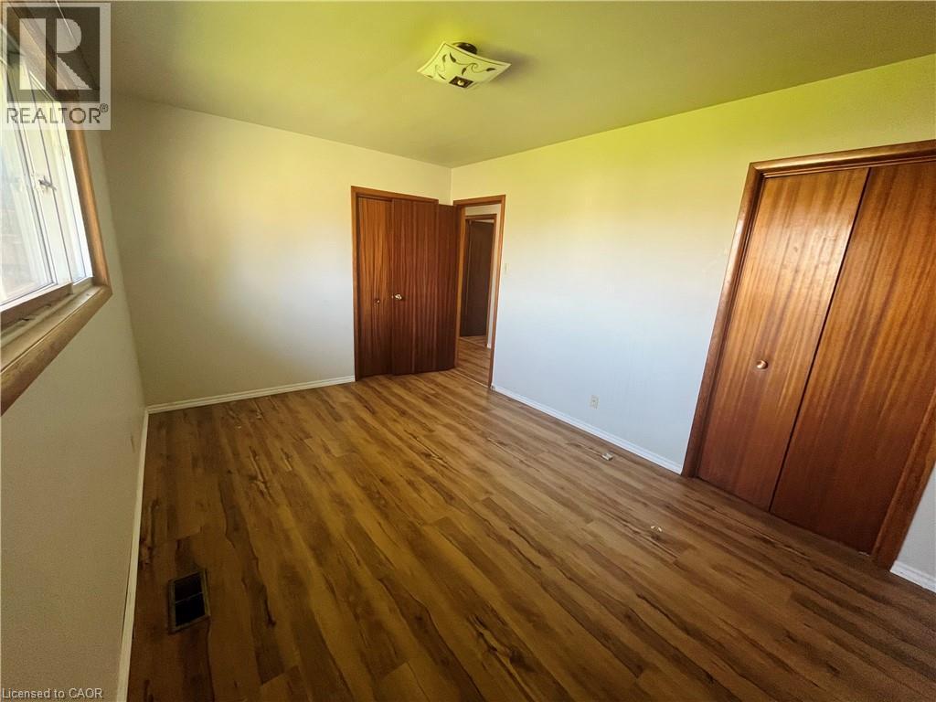 Room featuring wood-finish flooring, light-toned walls, and a ceiling-mounted light fixture - 157 Schweitzer Street, Kitchener, ON - Indoor Photo Showing Other Room