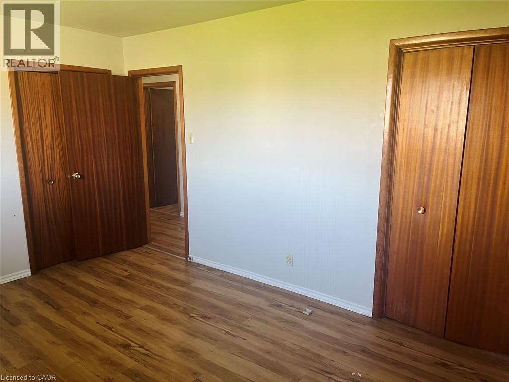 Interior space featuring wood-finish flooring, white baseboards, and light-toned walls - 157 Schweitzer Street, Kitchener, ON - Indoor Photo Showing Other Room