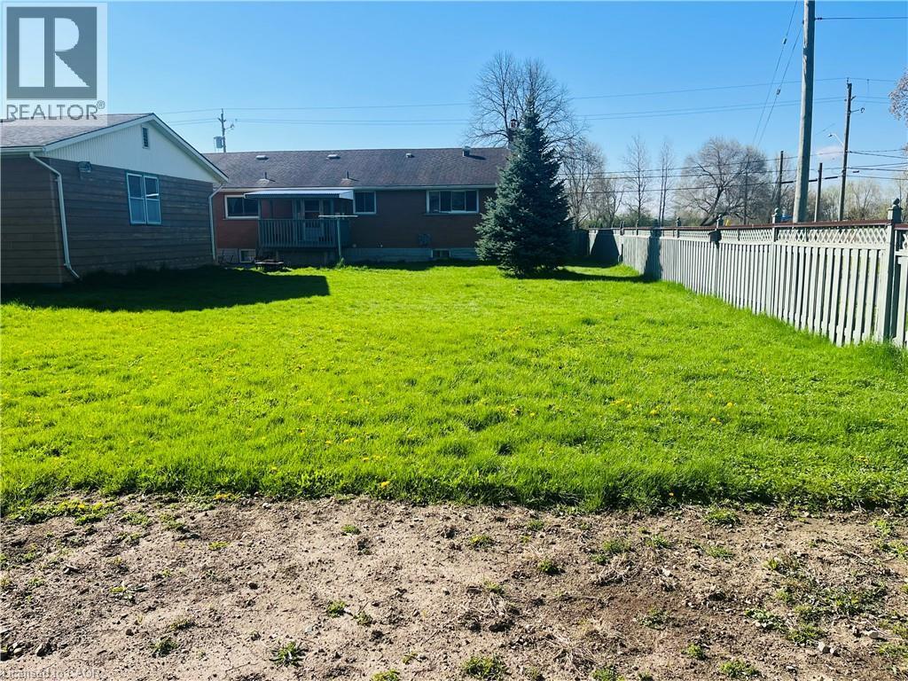 Expansive green lawn with a privacy fence bordering the property - 157 Schweitzer Street, Kitchener, ON - Outdoor