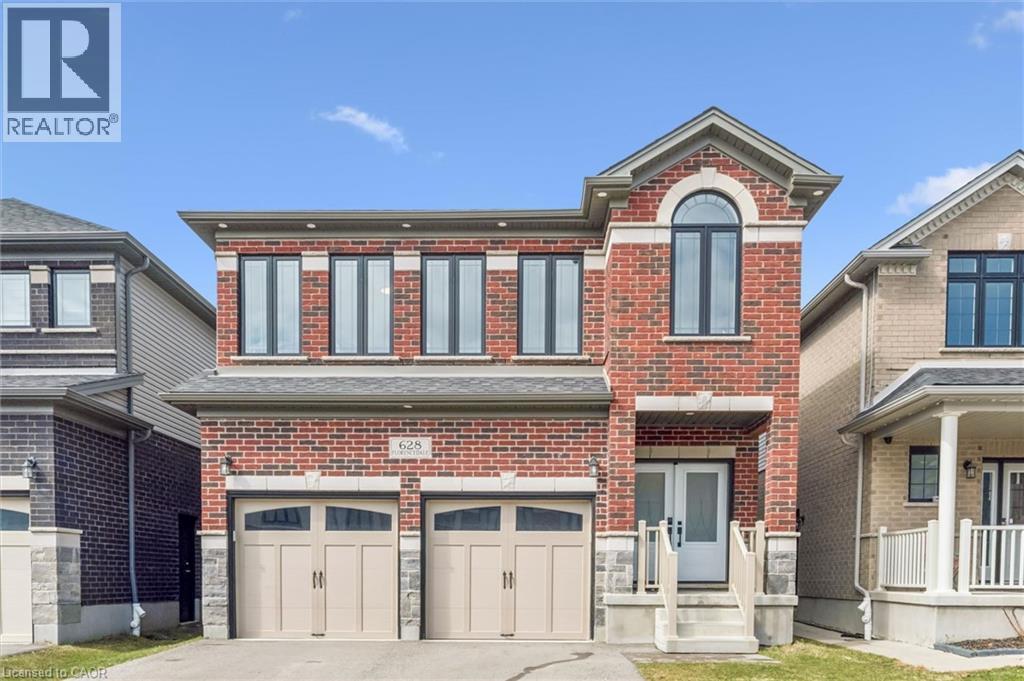 Brick facade residence featuring a two-car garage with arched panel doors - 628 Florencedale Crescent, Kitchener, ON