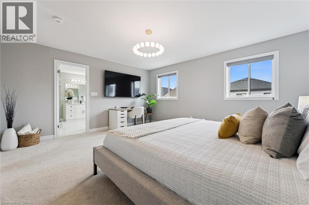 Spacious bedroom featuring light gray walls, plush carpeting, a modern ceiling light fixture, and two windows - 628 Florencedale Crescent, Kitchener, ON