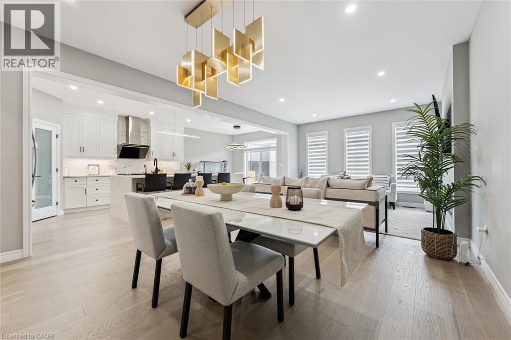 Open concept dining area featuring a contemporary chandelier, light wood-finish flooring, and recessed lighting - 628 Florencedale Crescent, Kitchener, ON
