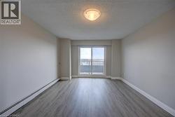 Spacious interior featuring wood-finish flooring, a neutral color palette, and a sliding glass door leading to a private balcony - 