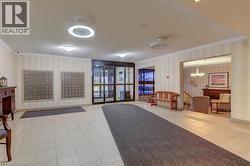 Bright, tiled entry foyer with automatic glass doors and two large mail stations - 
