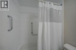 Bathtub with white subway tile surround and integrated grab bars - 