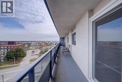 Elongated balcony with a glass and metal railing, offering expansive landscape views - 