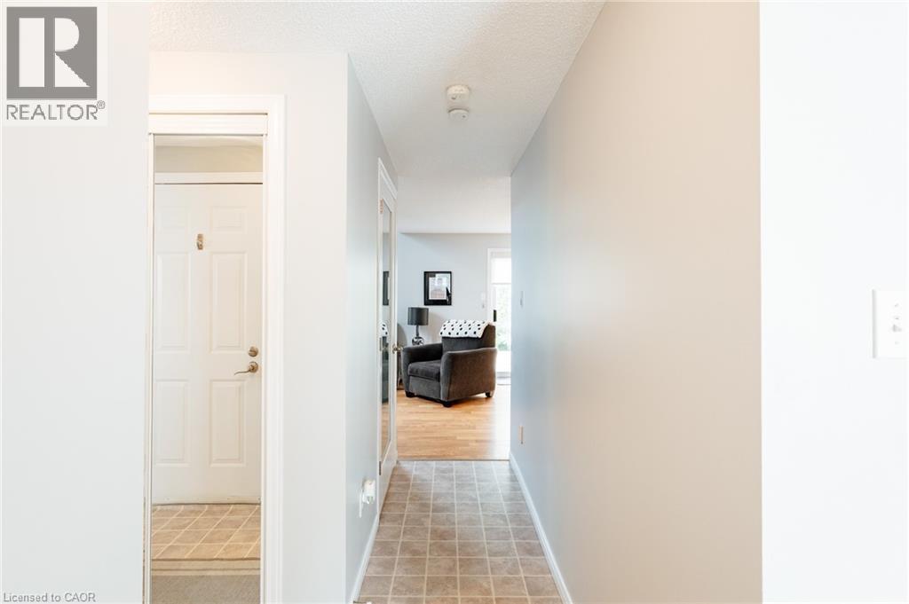 Hallway featuring neutral wall colors, textured ceiling, and tiled flooring - 560 Penny Lane, Waterloo, ON