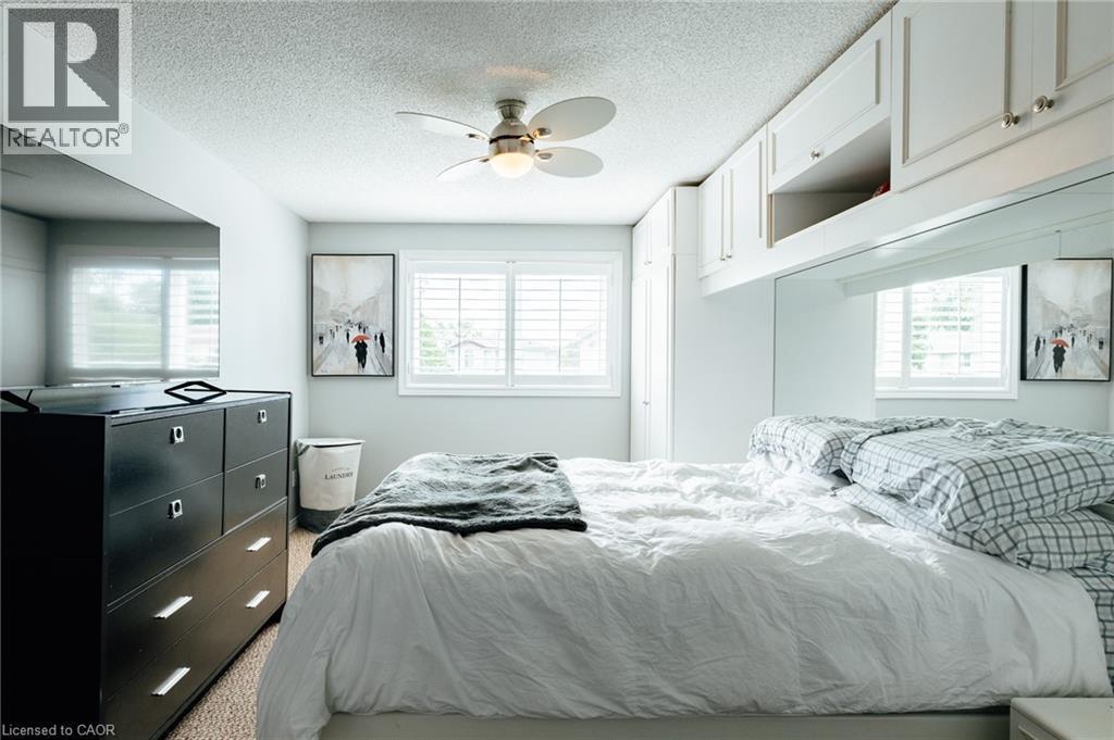 Integrated cabinetry with polished hardware, a ceiling fan, and window-mounted plantation shutters - 560 Penny Lane, Waterloo, ON