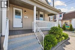Covered front porch featuring vertical siding and composite decking -