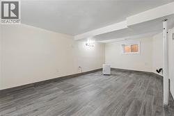 Spacious room featuring gray wood-finish tile flooring and a matching tile baseboard -