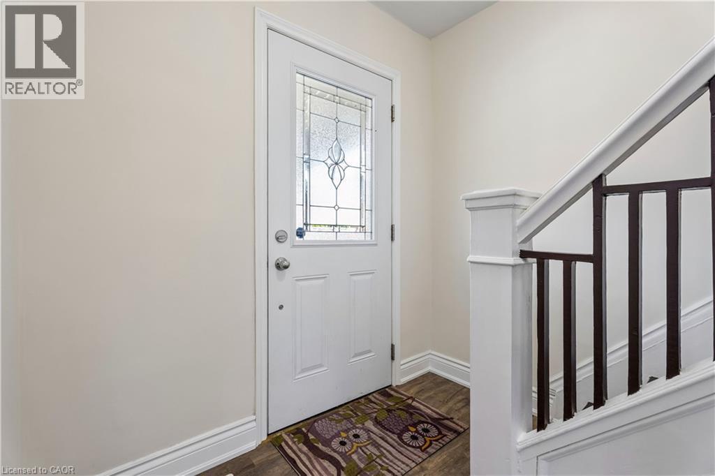 Entry door with decorative glass insert, white trim, and a classic paneled design - 180 Campbell Avenue, Hamilton, ON - Indoor Photo Showing Other Room