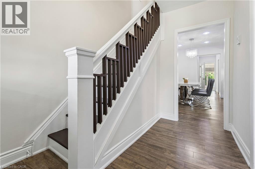 Interior staircase featuring a white newel post and dark wood balusters - 180 Campbell Avenue, Hamilton, ON - Indoor Photo Showing Other Room
