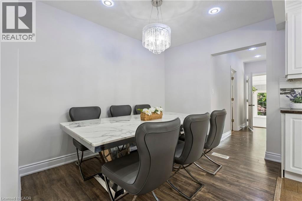 Dining area featuring a crystal chandelier, recessed lighting, and wood-finish flooring - 180 Campbell Avenue, Hamilton, ON - Indoor