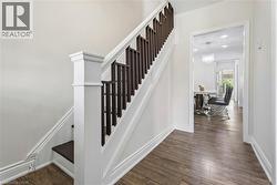 Interior staircase featuring a white newel post and dark wood balusters -