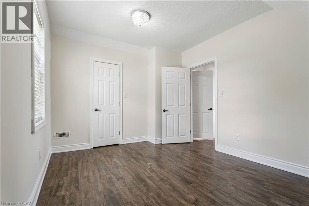 Interior room featuring wood-finish flooring, white trim, and light-toned walls - 180 Campbell Avenue, Hamilton, ON - Indoor Photo Showing Other Room