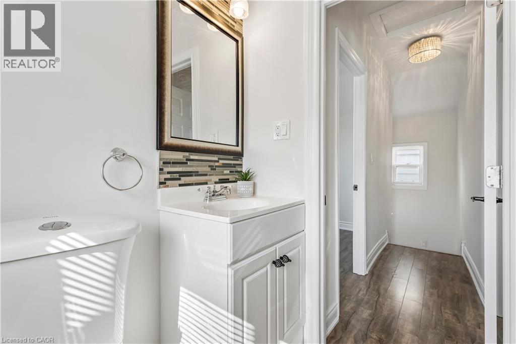 Contemporary bathroom vanity featuring a rectangular under-mount sink, chrome faucet, and white countertop - 180 Campbell Avenue, Hamilton, ON - Indoor Photo Showing Other Room
