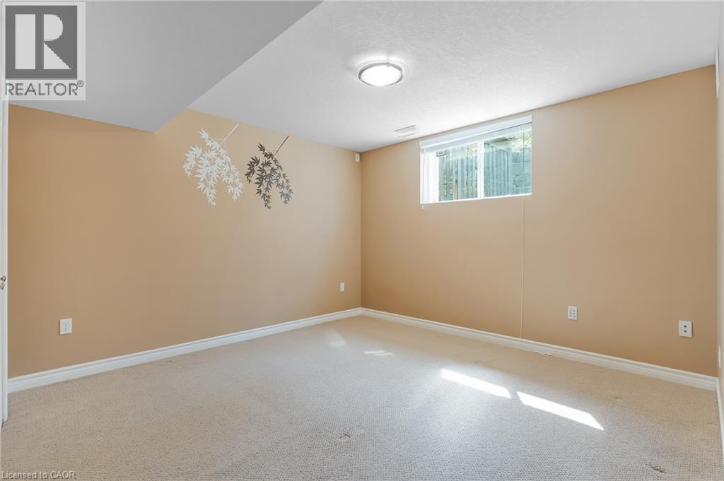 Carpeted room with neutral-toned walls, white baseboards, and a single window with a white frame - 227 Chestnut Hill Crescent, Kitchener, ON - Indoor Photo Showing Other Room
