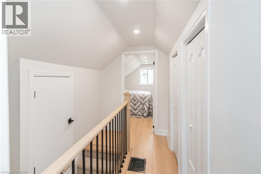Upper level hallway with wood-finish flooring - 297 Britannia Avenue, Hamilton, ON