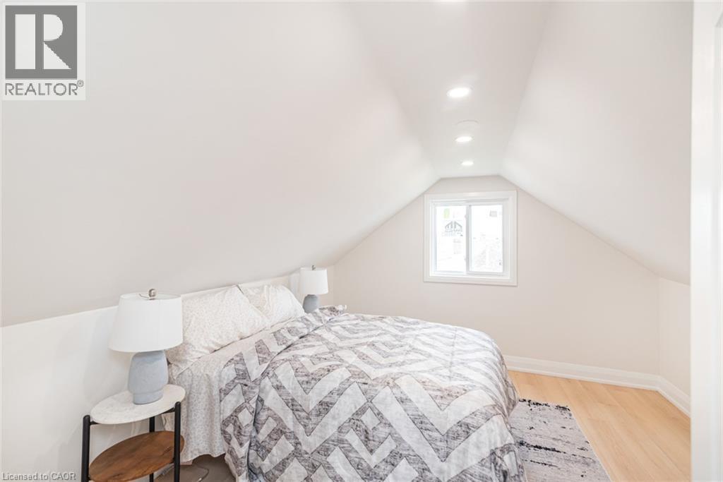 Bedroom featuring an angled ceiling, recessed lighting, a single window, and light wood-finish flooring - 297 Britannia Avenue, Hamilton, ON