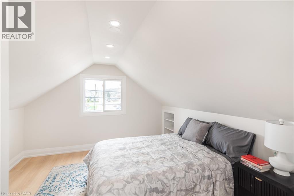 Attic room featuring a single window, recessed lighting, built-in shelving, light wood-finish flooring, and white baseboards - 297 Britannia Avenue, Hamilton, ON