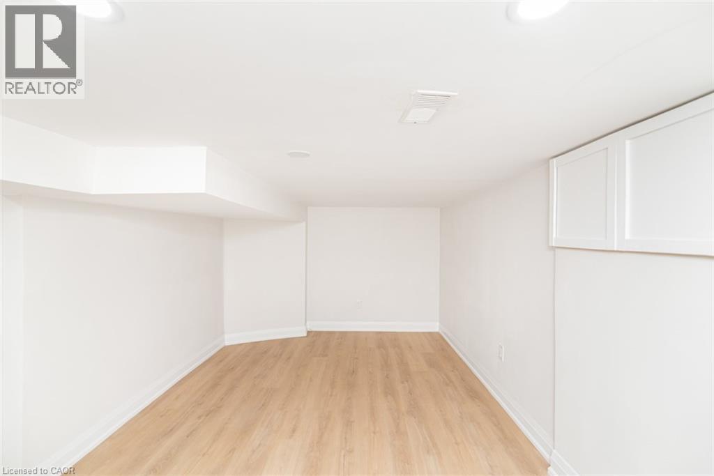 Finished room featuring wood-finish flooring, white walls, and recessed lighting - 297 Britannia Avenue, Hamilton, ON