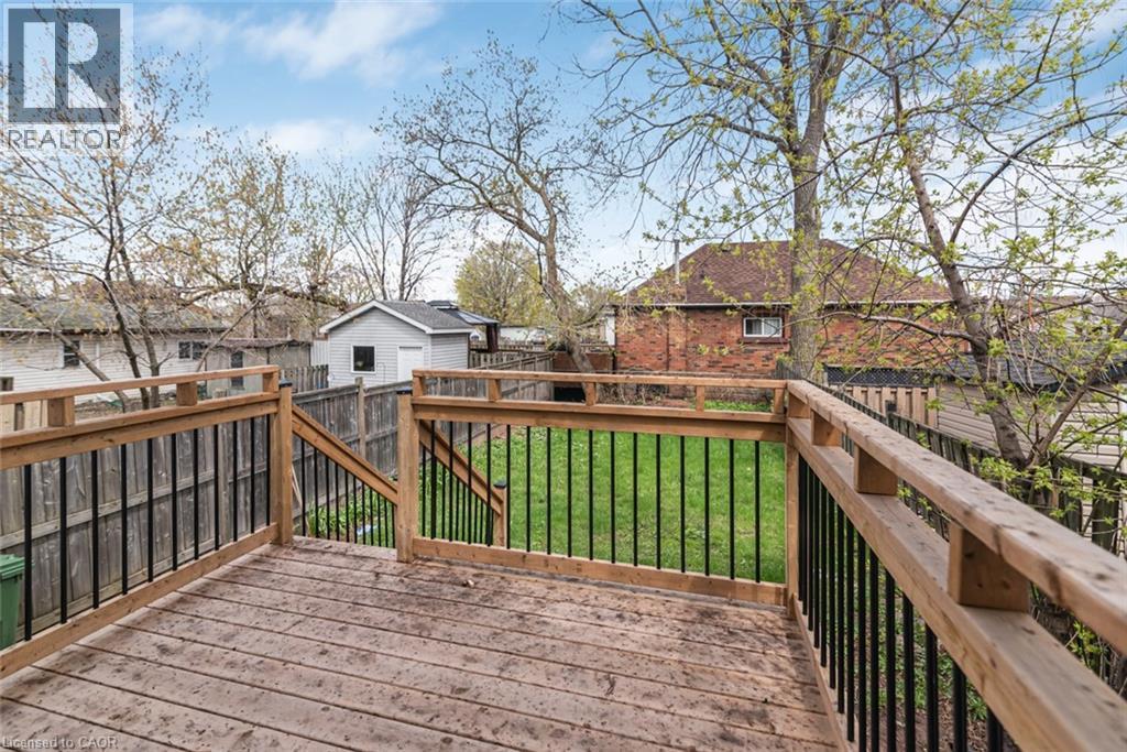Spacious wooden deck with natural wood railings and black metal balusters - 297 Britannia Avenue, Hamilton, ON