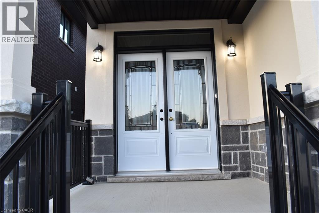 Double entry doors with decorative glass panels, flanked by two outdoor wall lanterns - 8 Dunlop Road, Hamilton, ON - Outdoor With Exterior