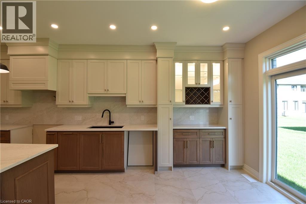 Contemporary kitchen featuring two-tone cabinetry, a black sink with a matte black faucet, and light-toned quartz counters and backsplash - 8 Dunlop Road, Hamilton, ON - Indoor Photo Showing Kitchen